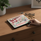 Mellow Monkey Indiana University zip pouch with colorful woven Hoosiers graphics on a wooden desk with keys and glasses