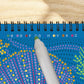 Mellow Monkey Into the Deep dot art activity book with metallic marker filling in a celestial pattern on wood table