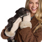 Mellow Monkey ivory knit gloves with faux fur cuffs worn by a smiling woman holding a small puppy