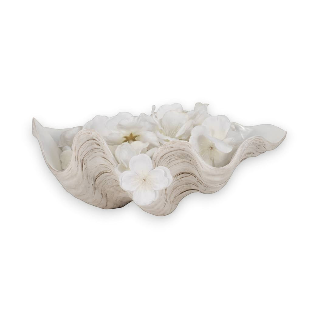 Mellow Monkey ivory resin shell bowl with a pearlized finish and wavy coastal design filled with white flowers.