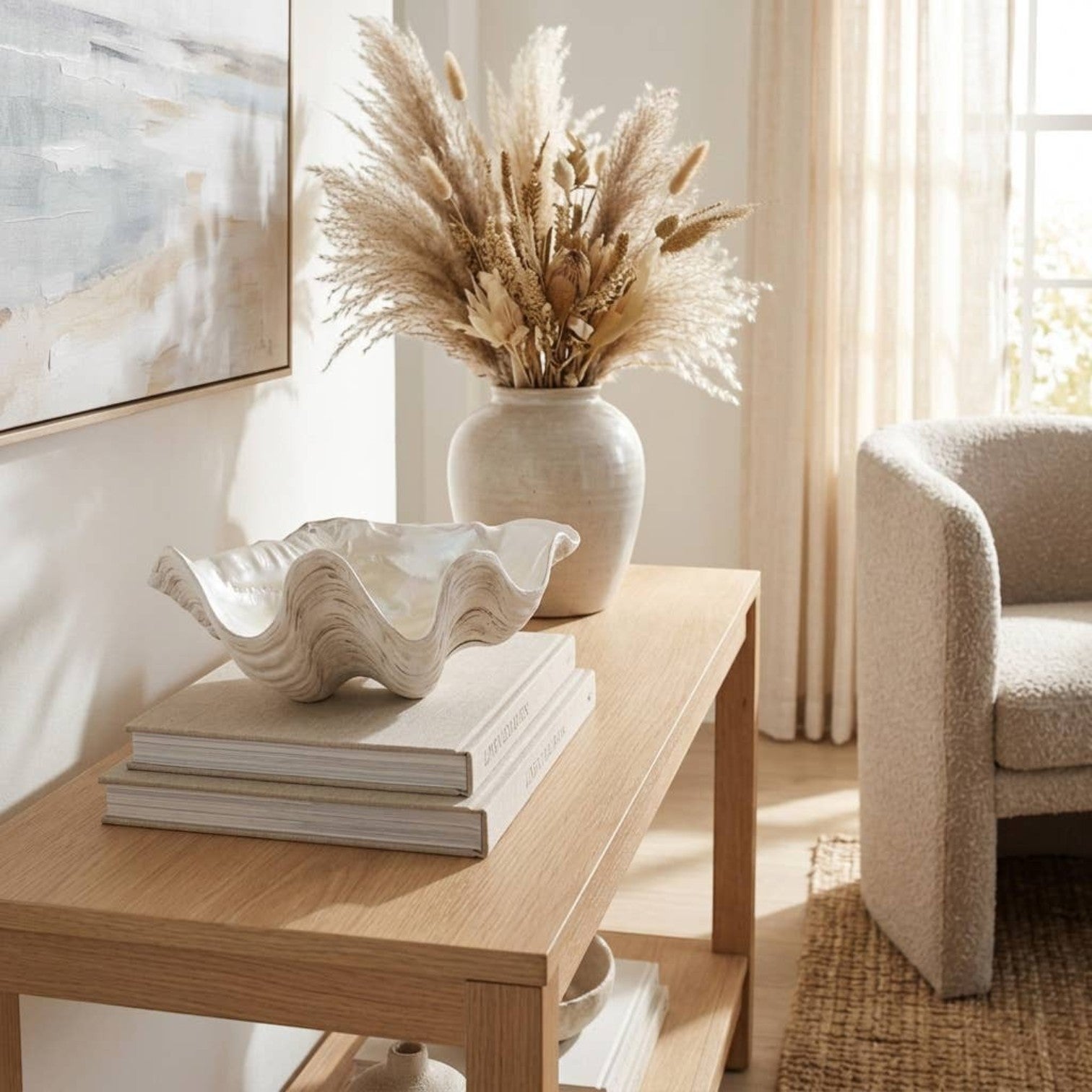 Mellow Monkey ivory resin decorative bowl with a coastal shell-inspired wave design displayed on stacked books.