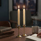 Mellow Monkey set of two 8.5-inch ivory twist taper flameless candles glowing on a wooden table with a book.