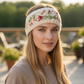 Mellow Monkey ivory hand-knit wool headband featuring delicate floral embroidery worn by a woman outdoors
