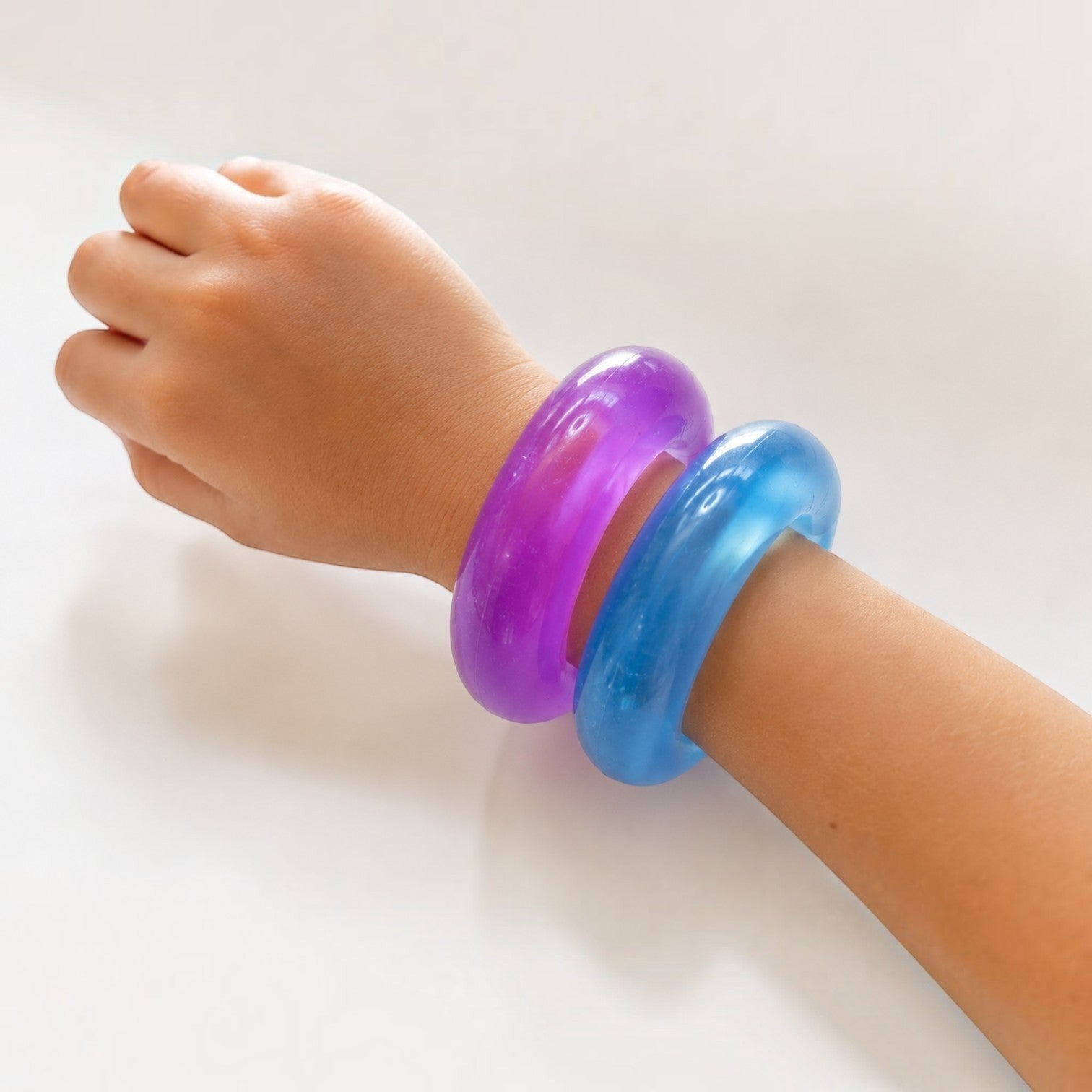 Mellow Monkey FEELZiES Jelly Donut Squishy wearable sensory fidget bracelets in purple and blue on a wrist