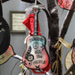 Mellow Monkey hand-painted wooden John Lennon Imagine guitar ornament with peace sign and musical notes on a tree.