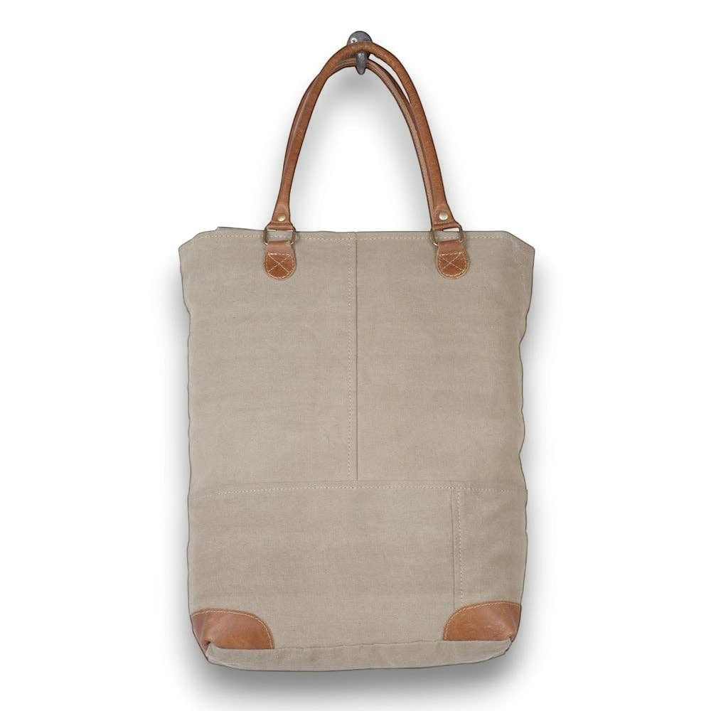 Mellow Monkey beige organic jute tote bag with brown leather handles and reinforced base corners.