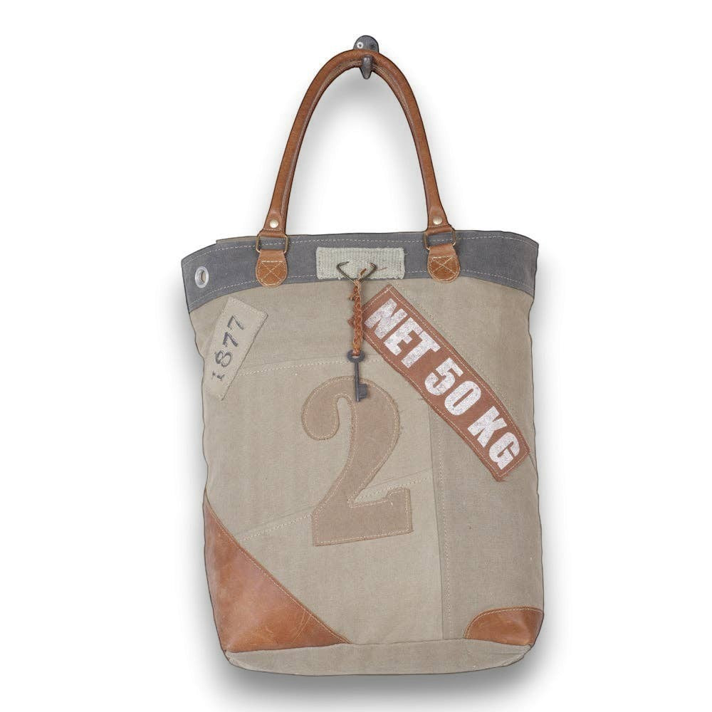 Mellow Monkey Quirky hues tote bag in beige organic jute with brown leather handles and vintage-style typography.