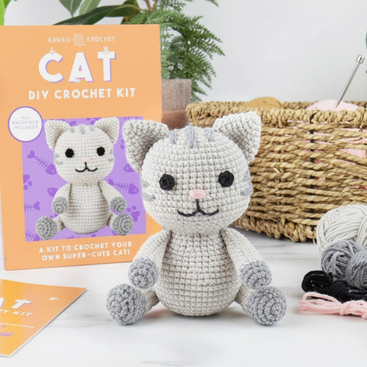 Mellow Monkey Kawaii Crochet Cat DIY kit featuring a finished grey amigurumi cat with yarn and instructions.