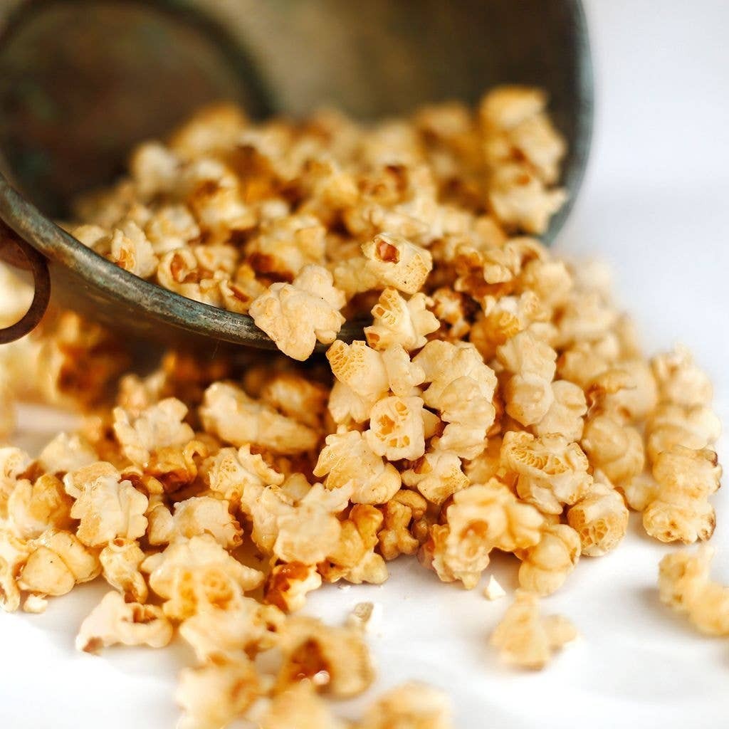 Mellow Monkey Old Fashioned Kettle Corn with a sweet and salty glaze spilling from a rustic metal bucket
