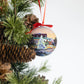 Mellow Monkey decoupage Christmas bauble featuring Kim Hovell Downtown artwork hanging on a pine tree branch