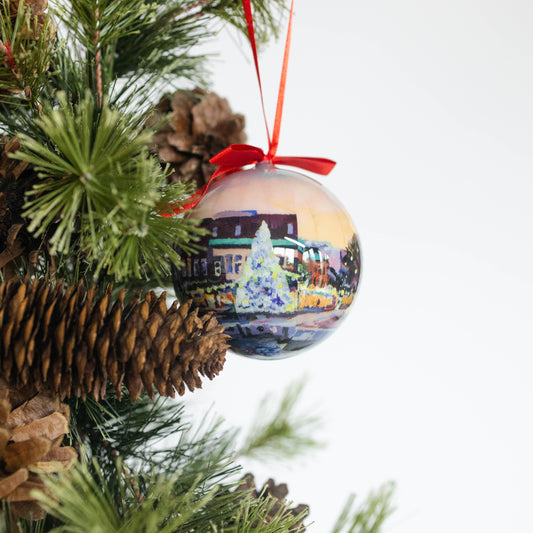 Mellow Monkey decoupage Christmas bauble featuring Kim Hovell Downtown artwork hanging on a pine tree branch