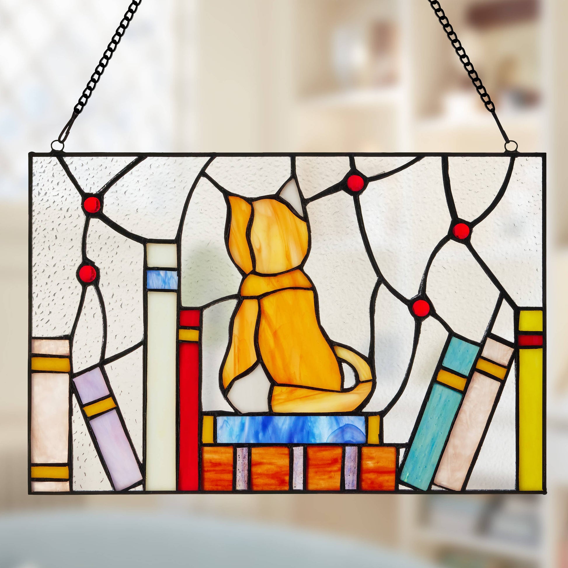Mellow Monkey stained glass window panel featuring a yellow kitten sitting on a stack of colorful books