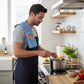 Mellow Monkey Knicks Grip tea towel draped over a man wearing an apron while cooking in a bright kitchen
