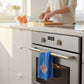 Mellow Monkey Knicks Zone tea towel hanging on a modern oven handle in a bright kitchen