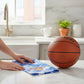 Mellow Monkey Knicks Flash tea towel with blue tie-dye pattern and NBA team logo on a kitchen counter with basketball