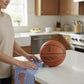 Mellow Monkey Knicks Classic tea towel with blue stripes and team logo held by a person next to a basketball
