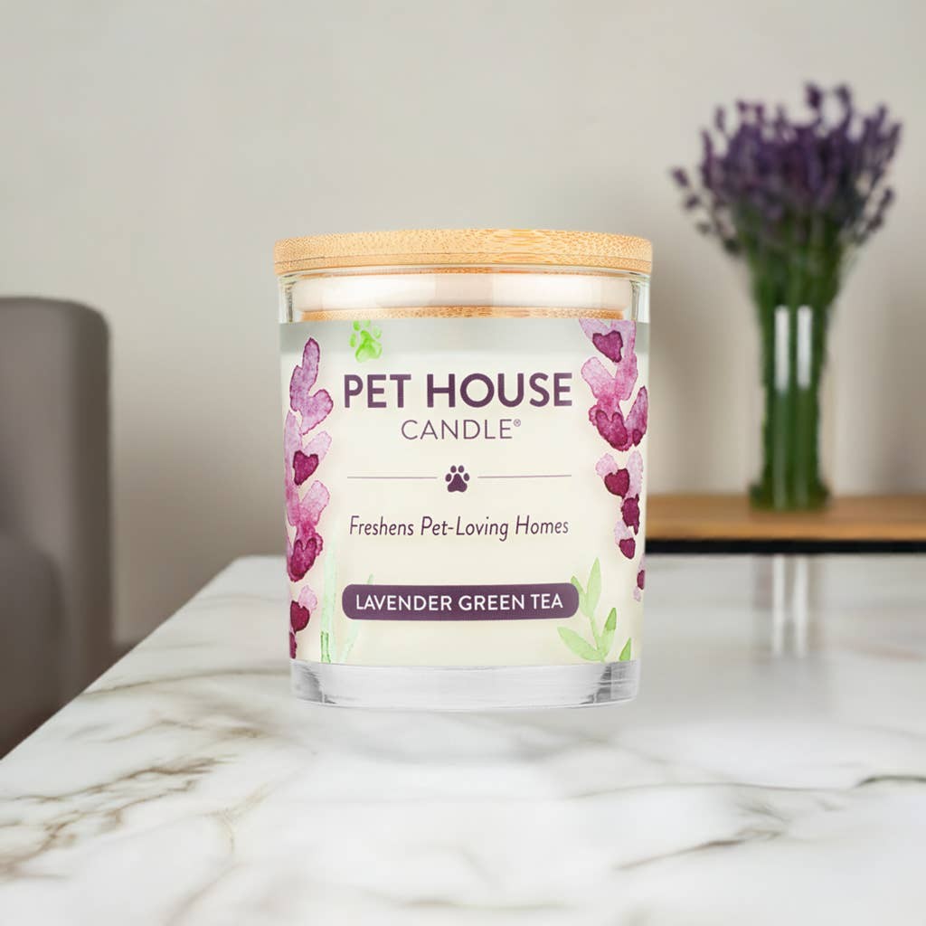 Mellow Monkey Pet House Lavender Green Tea candle in a glass jar with a wooden lid on a marble table.
