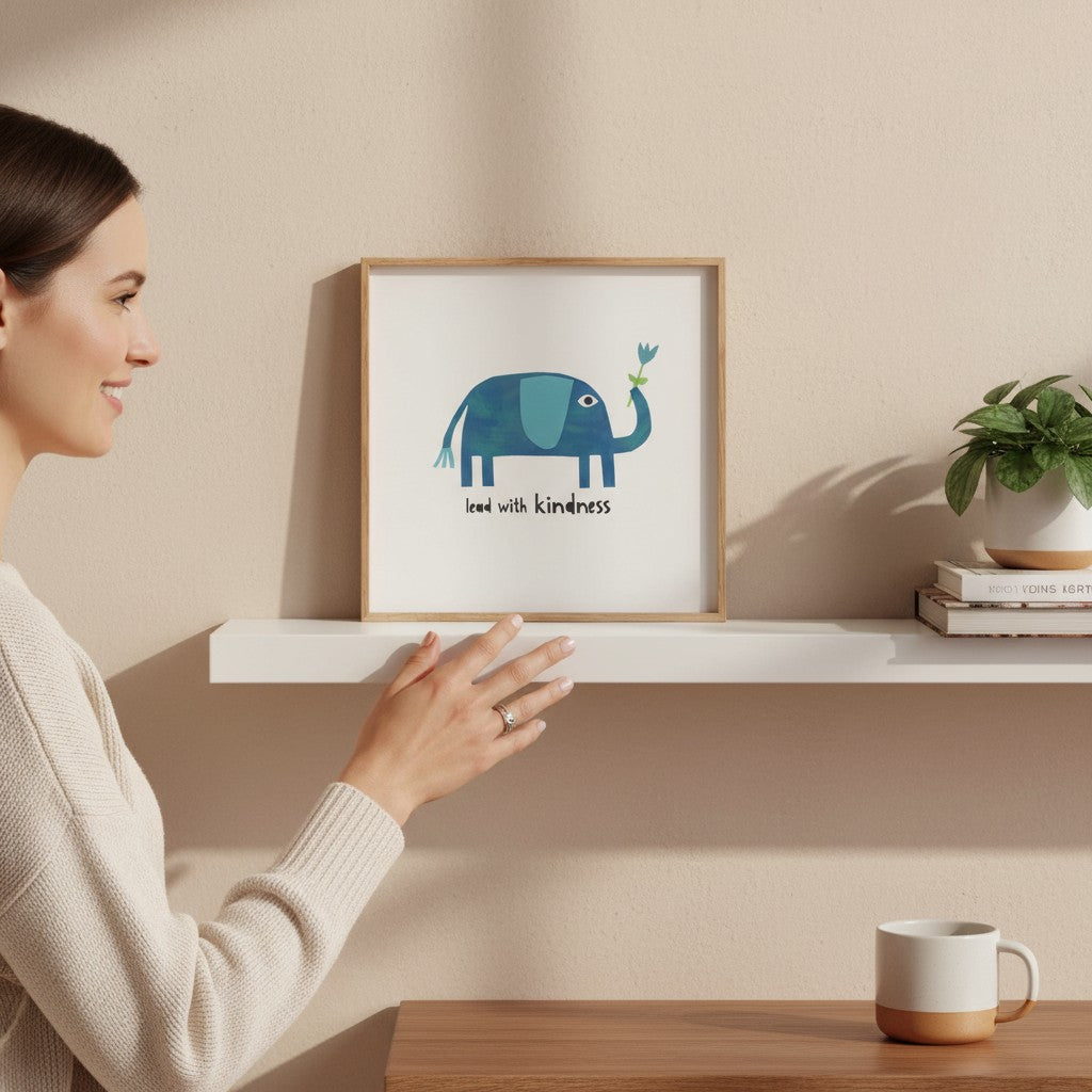 Mellow Monkey Lead with Kindness framed art print featuring a blue elephant holding a flower. Wood frame, 8-3/4 x 8-3/4-in.