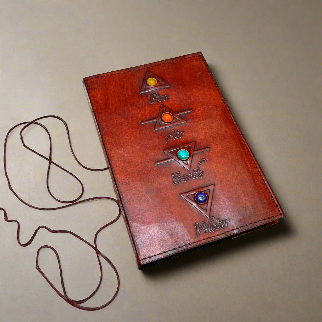 Mellow Monkey reddish-brown leather journal with embossed elemental symbols and gemstone accents, featuring a cord closure.