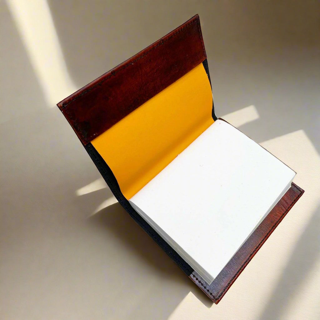 Mellow Monkey reddish-brown leather journal with elemental symbols and cord closure, yellow interior lining.