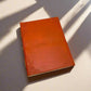 Mellow Monkey hand-stitched tan leather journal with debossed geometric corners and elastic closure. Unlined pages.