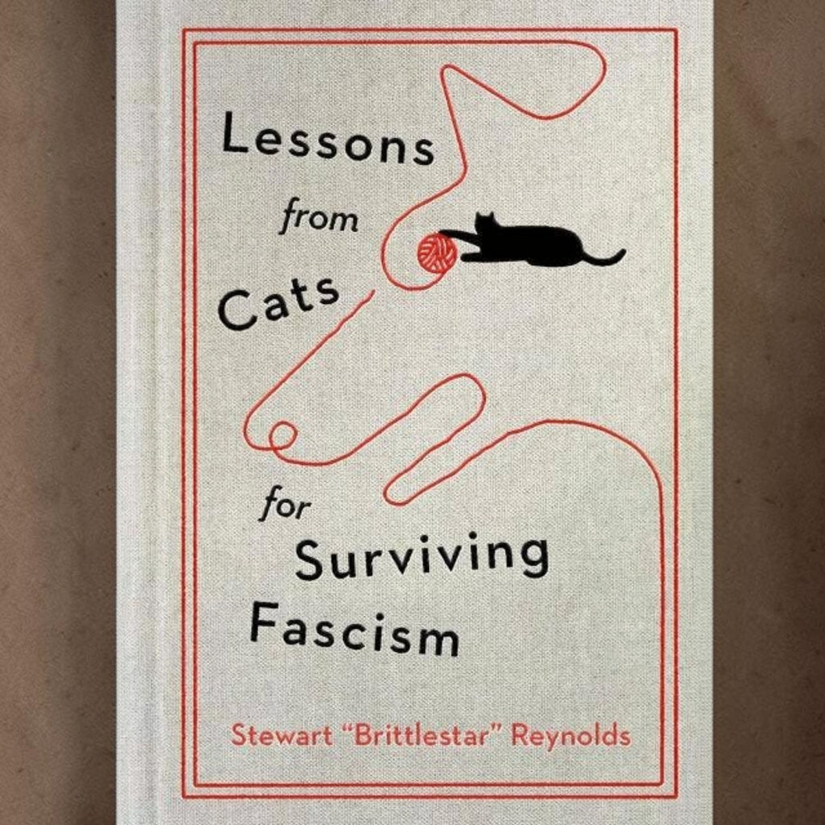 Mellow Monkey hardcover book Lessons from Cats for Surviving Fascism with a minimalist cat and yarn line art cover