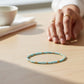 Mellow Monkey light blue seed bead bracelet with 18K gold plated brass accents on a wooden table