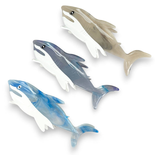 Mellow Monkey light blue shark-shaped hair claw clip with a unique marbled texture pattern for styling hair.