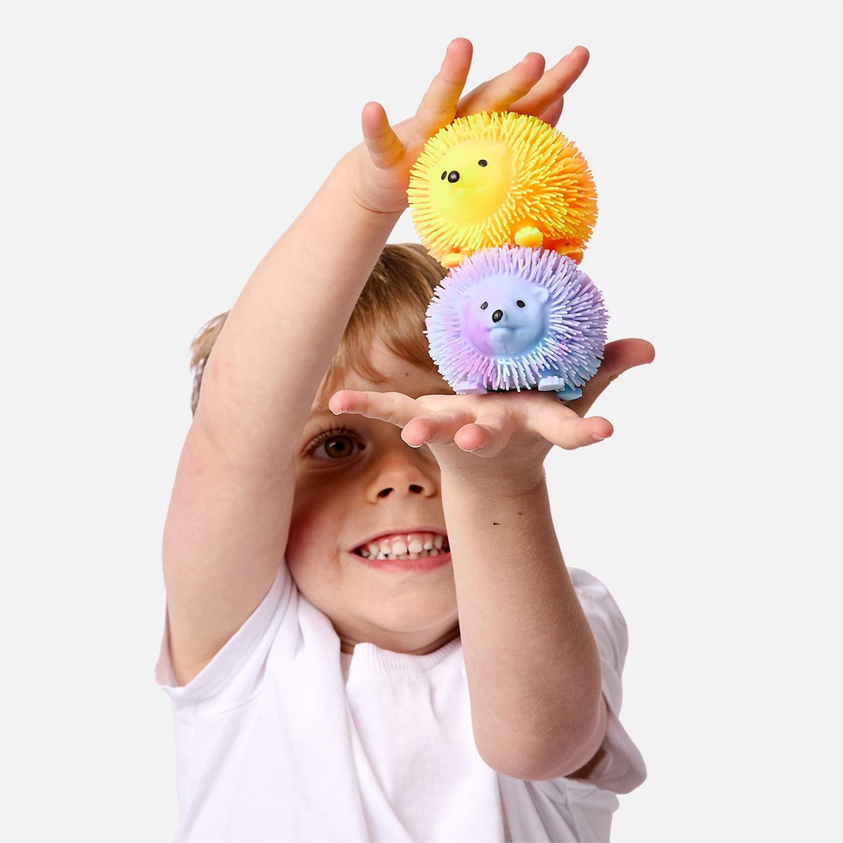 Mellow Monkey light up hedgehog sensory toys in yellow and purple held by a smiling child