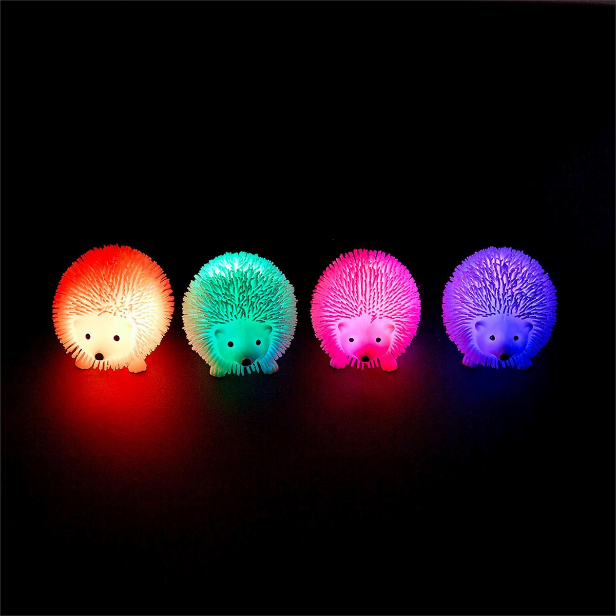 Mellow Monkey light up hedgehog sensory toys in orange, green, pink, and blue glowing on a black background.
