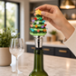 Mellow Monkey Light-Up Tree Bottle Stopper with colorful LED lights and a yellow star topper on a wine bottle