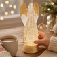 Mellow Monkey 13-inch lighted angel water lantern with gold glitter wings and base on a wooden table