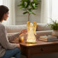 Mellow Monkey lighted angel figurine with swirling gold glitter in a water-filled globe on a wooden table