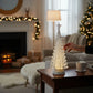 Mellow Monkey 15-inch silver tabletop Christmas tree with swirling glitter and warm LED lights on a wooden side table.