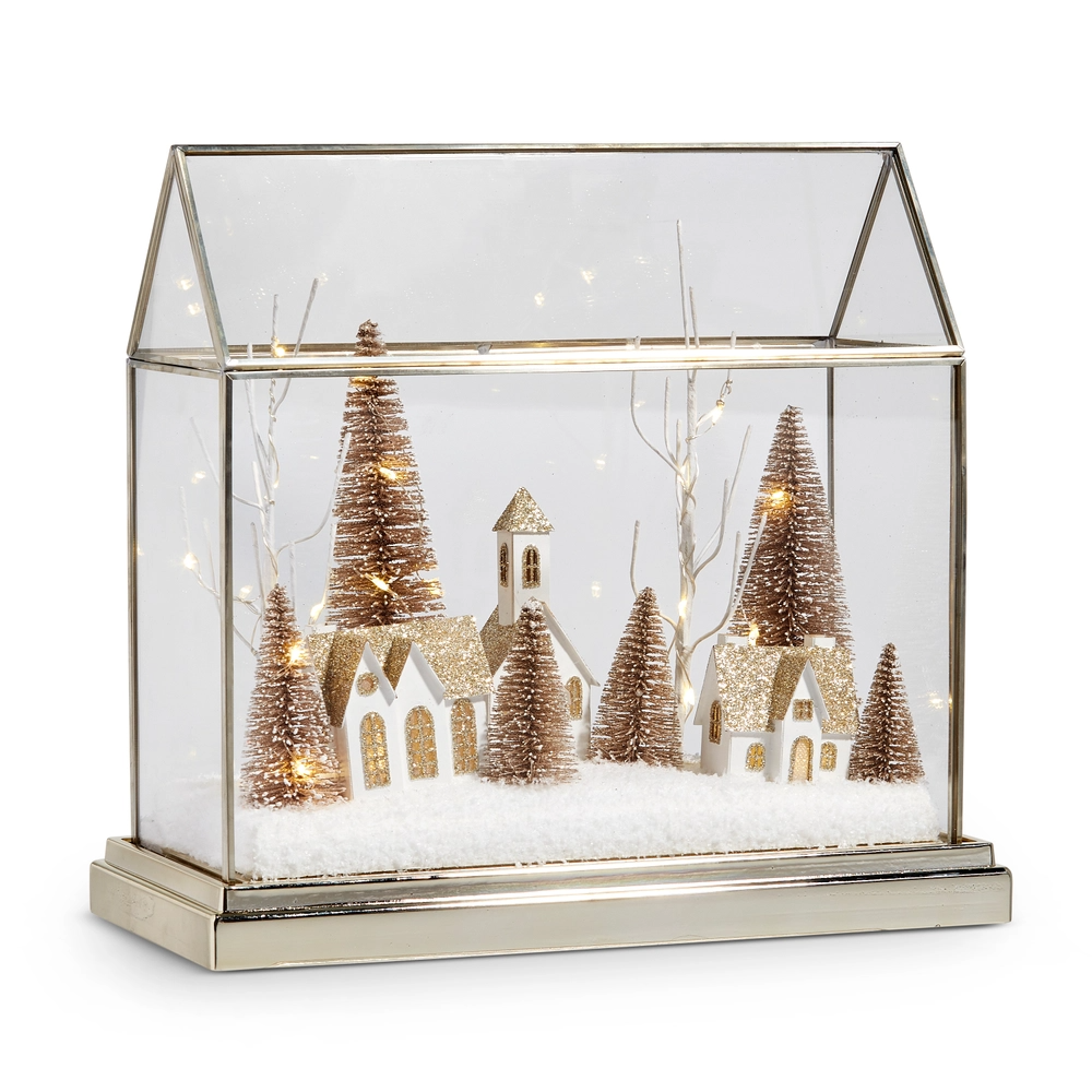 Mellow Monkey lighted snowy village terrarium with miniature gold houses and bottle brush trees in a glass house case.