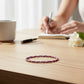 Mellow Monkey lilac seed bead bracelet with 18K gold plated brass accents resting on a wooden desk.