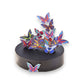 Mellow Monkey magnetic desktop sculpture featuring colorful stainless steel butterfly pieces on a black circular base.