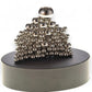 Mellow Monkey magnetic sculpture desk toy with silver stainless steel balls stacked on a round black base.