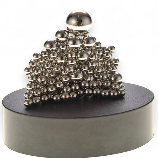 Mellow Monkey magnetic sculpture desk toy with silver stainless steel balls stacked on a round black base.