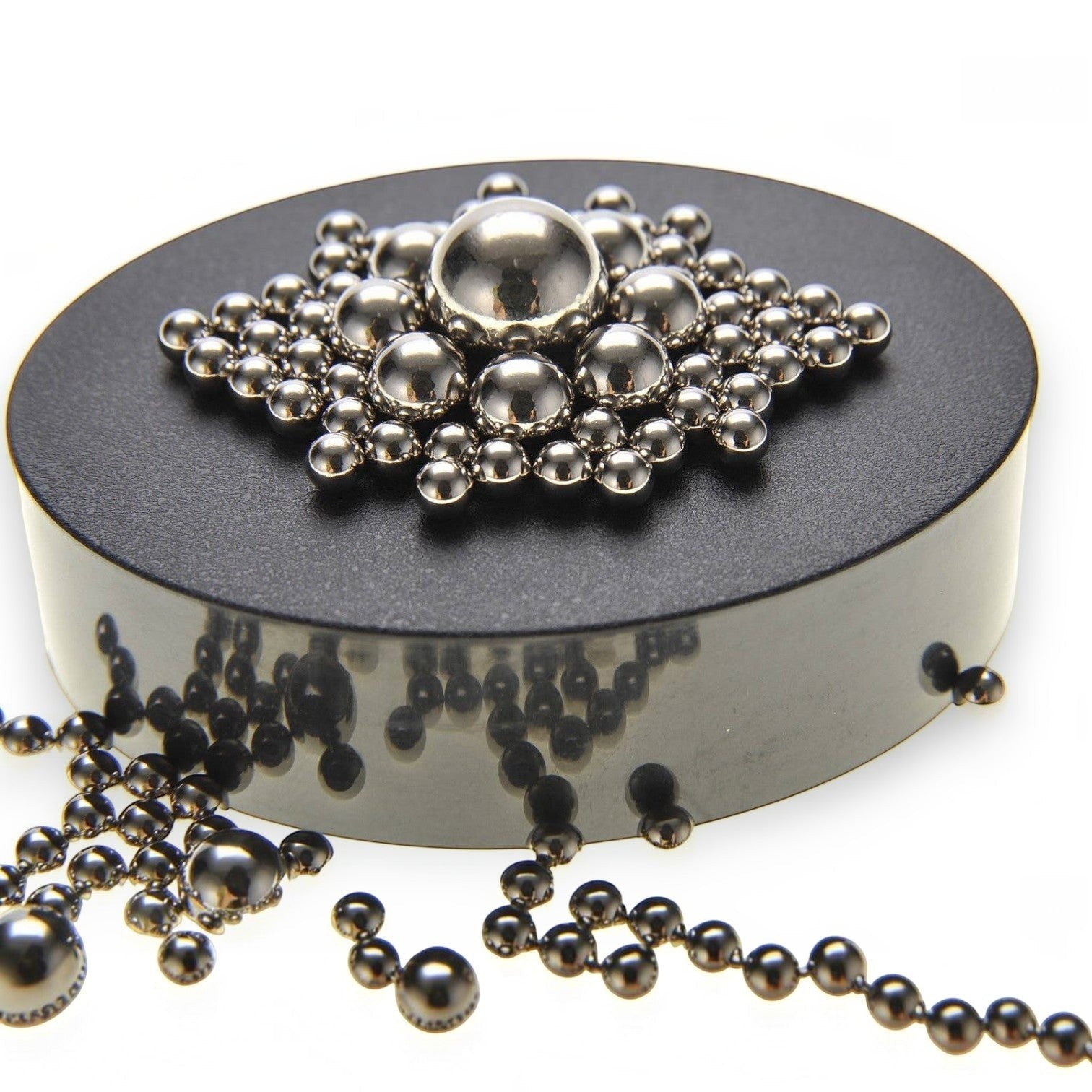 Mellow Monkey magnetic sculpture desk toy with stainless steel balls arranged in a star pattern on a black base.