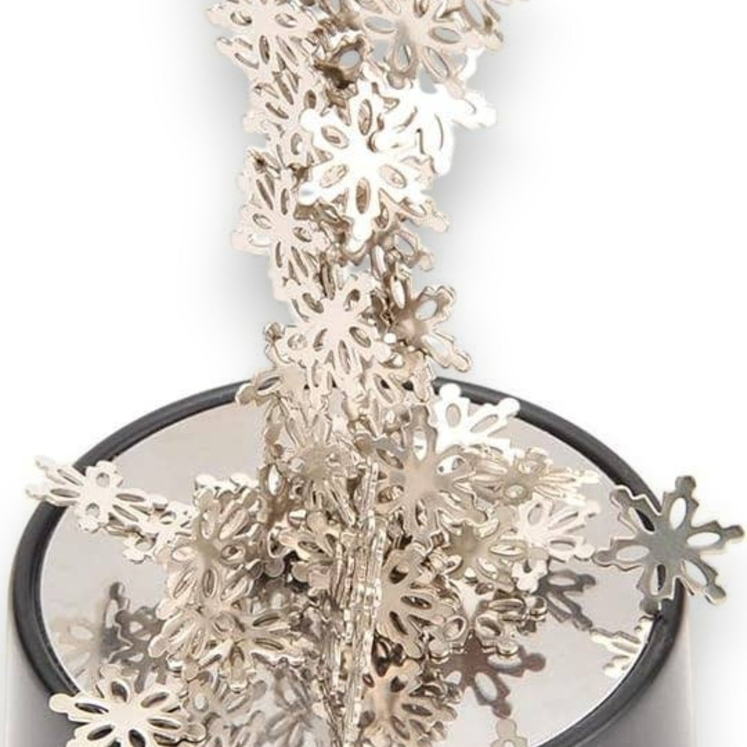 Mellow Monkey magnetic desktop sculpture featuring silver stainless steel snowflake pieces on a circular base.