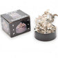 Mellow Monkey magnetic desktop sculpture with stainless steel moon and star pieces on a black base next to its box.