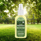 Mellow Monkey Marie Originals plant-based DEET-free insect repellent spray bottle in a sunny outdoor forest setting.