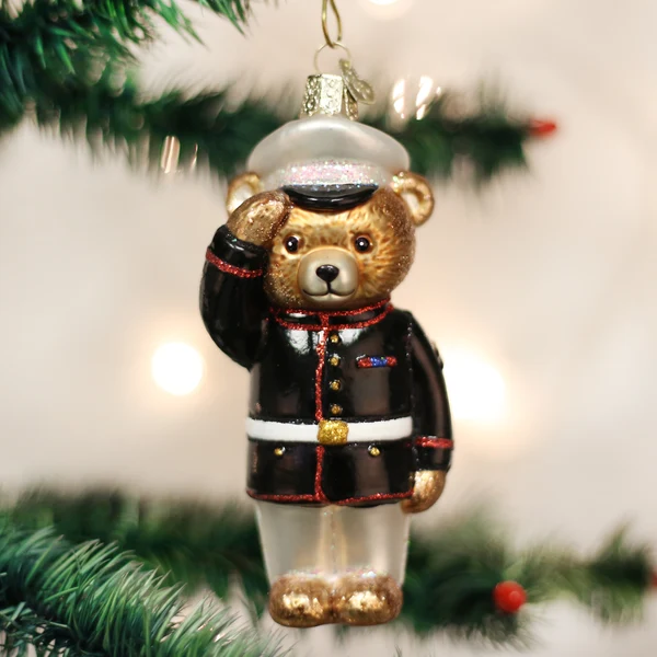 Mellow Monkey Marine Bear blown glass ornament wearing a dress blue uniform and saluting, hanging on a Christmas tree.