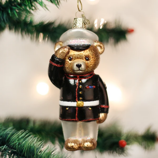 Mellow Monkey Marine Bear blown glass ornament wearing a dress blue uniform and saluting, hanging on a Christmas tree.