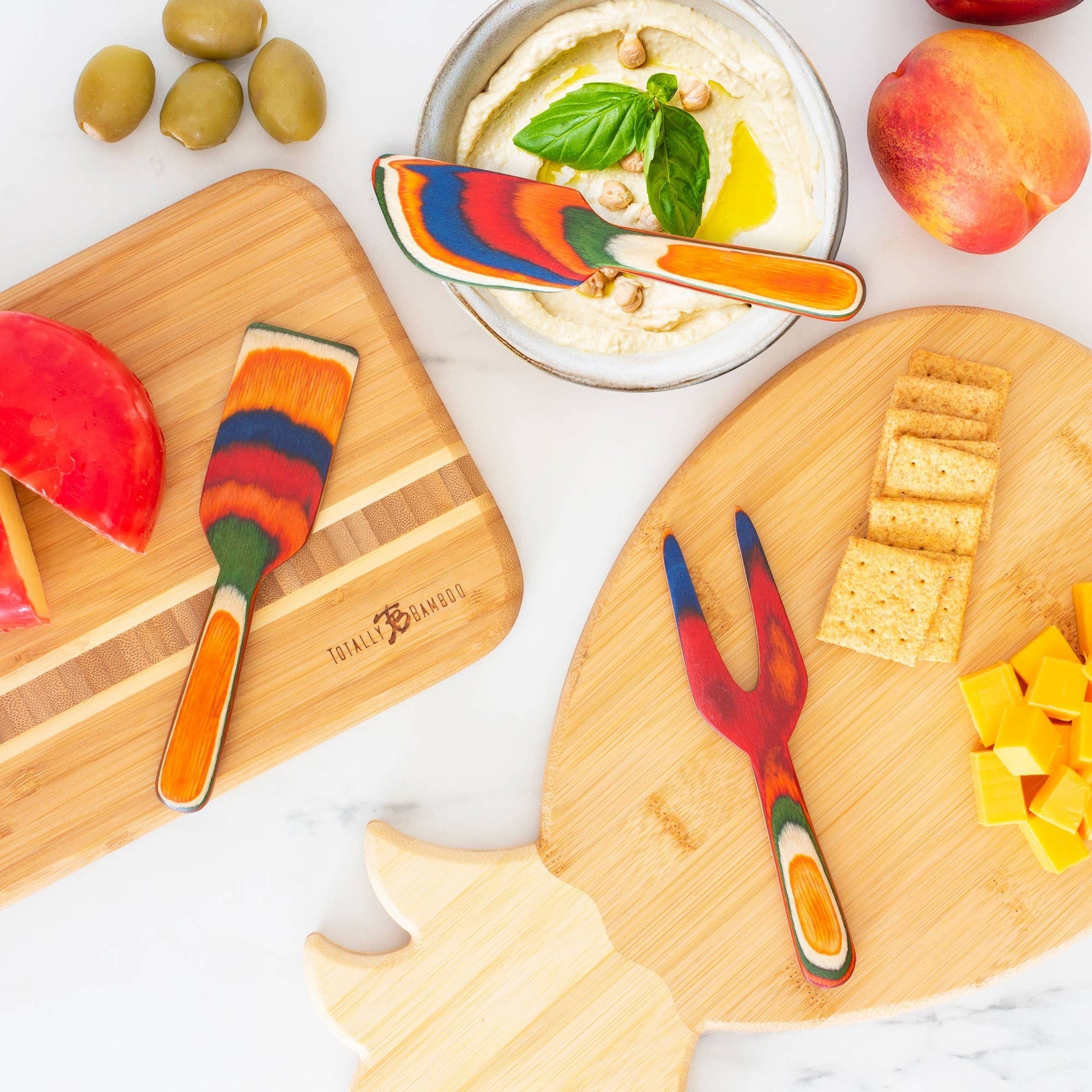 Mellow Monkey Marrakesh Collection 3-piece cheese tool set made of colorful layered birch wood. Includes spreader, fork, and knife.