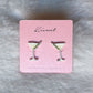 Mellow Monkey martini cocktail stud earrings with olive garnish on a pink display card