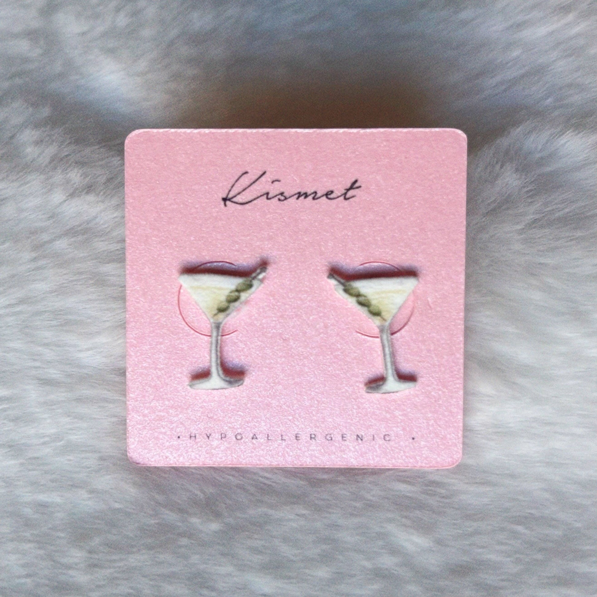 Mellow Monkey martini cocktail stud earrings with olive garnish on a pink display card