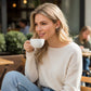 Mellow Monkey martini cocktail stud earrings worn by a blonde woman drinking coffee at an outdoor cafe.