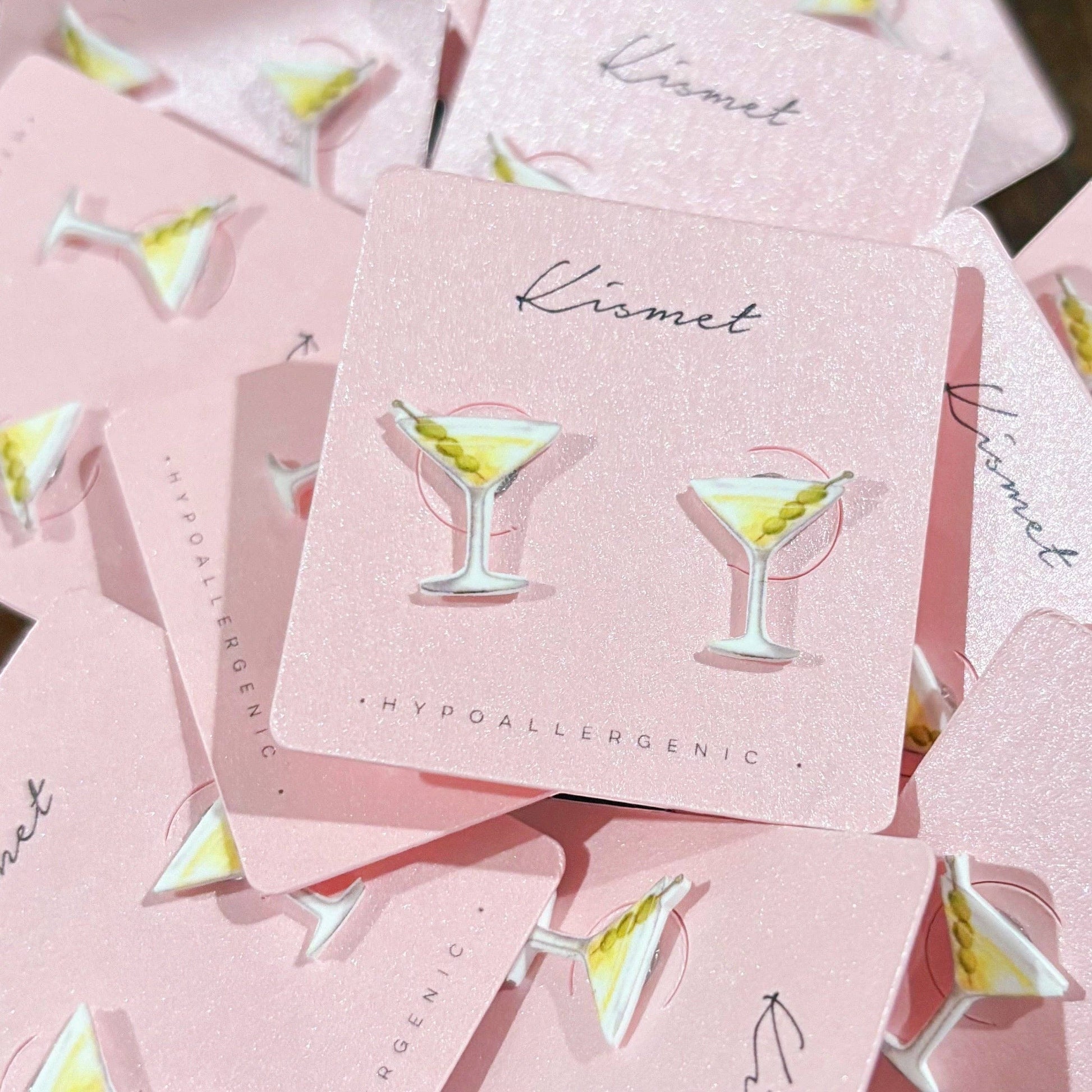 Mellow Monkey martini cocktail stud earrings with olive garnish on pink display cards